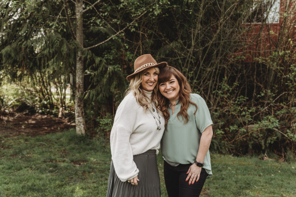 Portrait of owners Lorry Green and Hollie Wesoloski. Both women are smiling towards the camera and leaning on each other